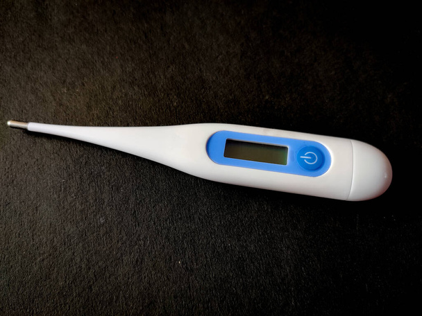 Digital Thermometer for measuring temperature. Isolated on black background. - Photo, Image