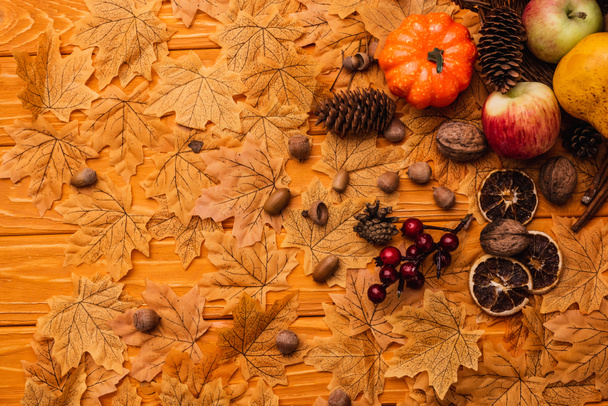 top view of autumnal decoration and food on golden foliage on wooden background - Valokuva, kuva
