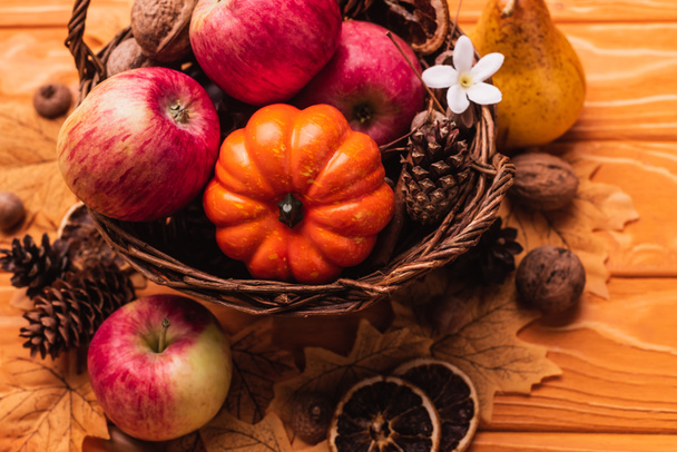 wicker basket with autumnal harvest on wooden background - Photo, Image