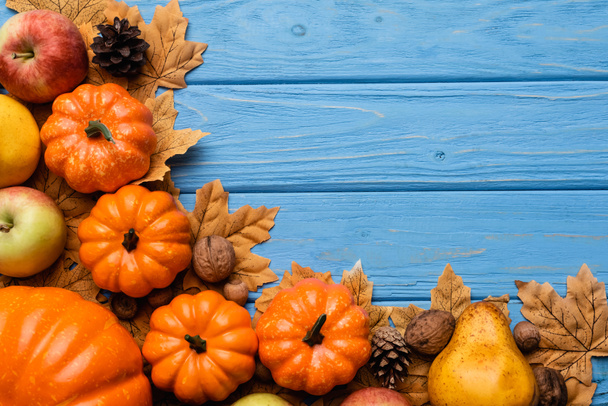 top view of autumnal harvest and foliage on blue wooden background - Photo, Image