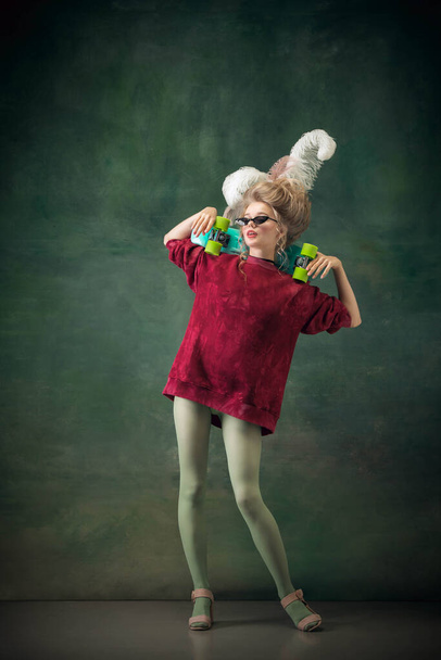 Young woman as Marie Antoinette on dark background. Retro style, comparison of eras concept. - 写真・画像