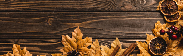 top view of autumnal decoration and foliage on brown wooden background, panoramic shot - Photo, Image