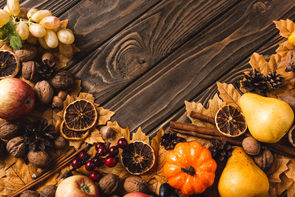 Blick von oben auf Herbsternte und Laub auf braunem Holzgrund - Foto, Bild