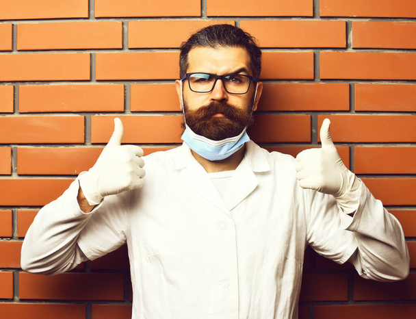Bearded brutal caucasian doctor or postgraduate student in gloves - Фото, зображення