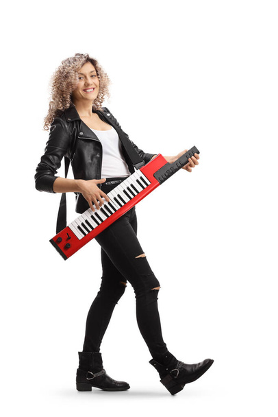 Full length portrait of a woman smiling and playing a keytar synthesizer isolated on white background - Fotó, kép