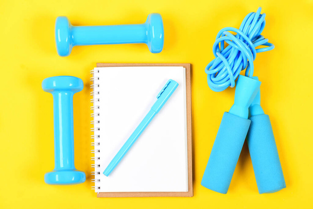 Bloco de notas e ferramentas de fitness. Equipamento de caderno, caneta e ginásio - Foto, Imagem