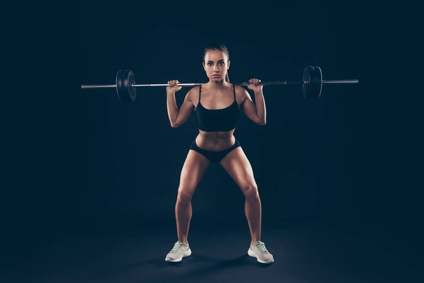 Full length photo short sport suit lady heavy barbell shoulders competition serious try hard isolated black background - Φωτογραφία, εικόνα