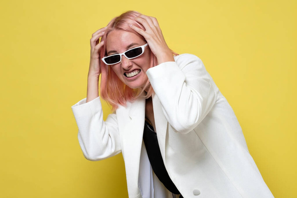 Frustrada e estressada jovem empresária em terno branco e óculos de sol
. - Foto, Imagem
