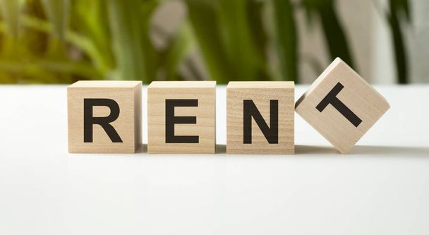 Concept word RENT on wooden cubes on a light background - Photo, Image