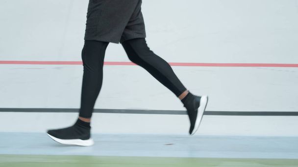 Male jogger training at stadium track. Athlete legs running on racetrack - Photo, Image