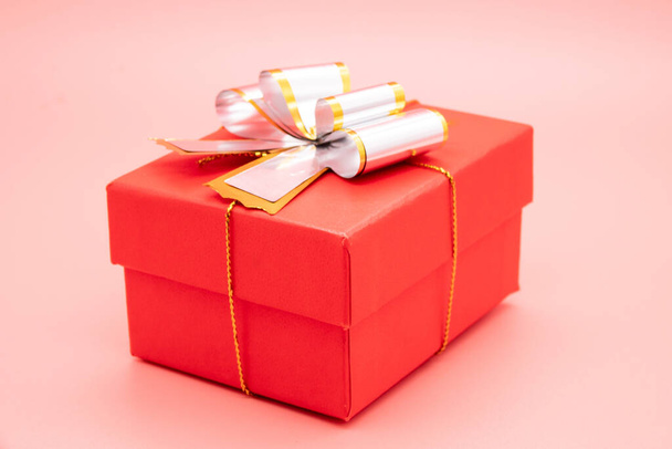 Red gift box with white ribbon and presents on pink - Foto, imagen