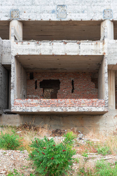Ruinas de un edificio soviético destruido con un paisaje cubierto de árboles - Foto, Imagen