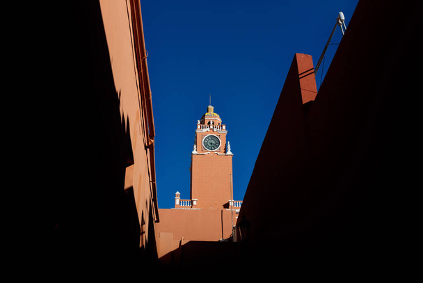 Torre del reloj rojo del Centro Cultural Olimpo en el cielo azul sin nubes en la ciudad colonial de Mérida, Yucatán, México - Foto, Imagen