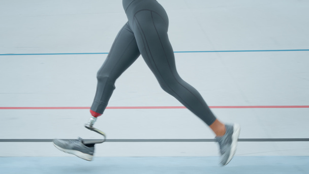 Biegacz ze sztuczną kończyną robi cardio na torze. Sportowiec biegający na świeżym powietrzu - Zdjęcie, obraz