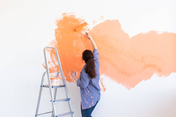 Lovely woman painting wall. Renovation, redecoration and repair concept. - Foto, Imagen