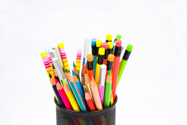 多くの異なる色の木製の鉛筆クレヨンを含む黒い色のプラスチック製の鉛筆ホルダー - 写真・画像