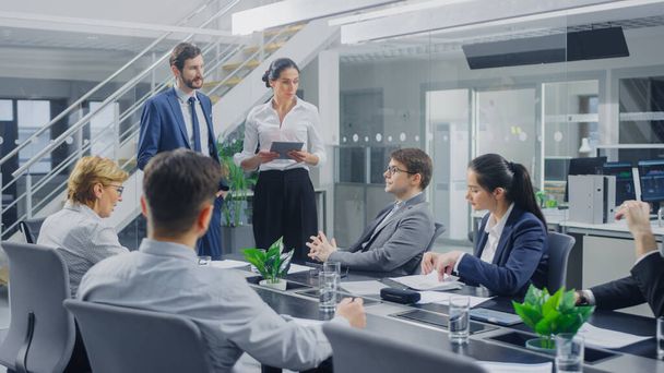 In the Corporate Office Meeting Room: Male and Female Company Growth and Development Executives Deliver a Speech to a Board of Directors Sitting at the Conference Table - Foto, imagen