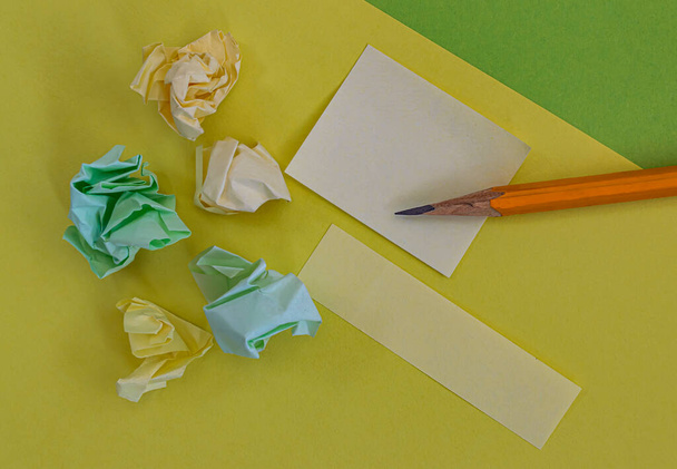 lápis notas adesivos e papel amassado em um backgroun amarelo
 - Foto, Imagem