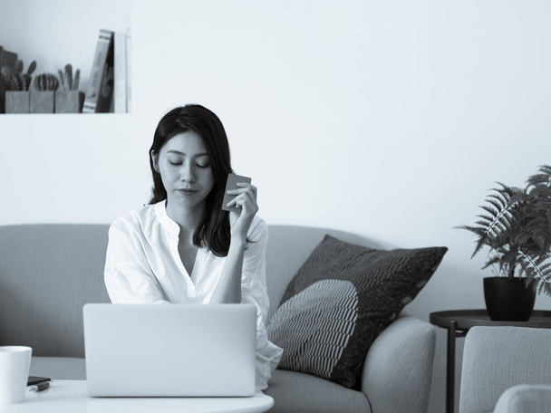 Young woman shopping online with credit card and laptop at home - Photo, Image