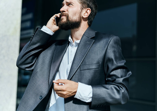 üzletember öltönyben beszél telefonon a szabadban üzleti menedzser ügyvezető - Fotó, kép