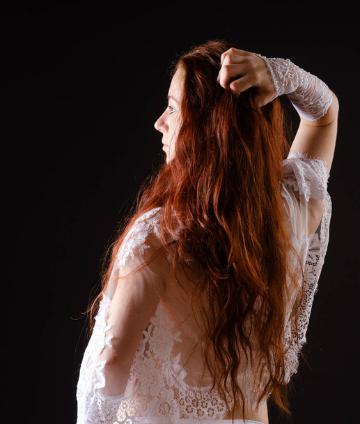 beautiful woman with long red hair on black - Fotó, kép