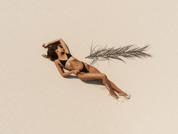Top Aerial Drone View of Woman in Swimsuit Bikini Relaxing and Sunbathing on Beach - Foto, Bild