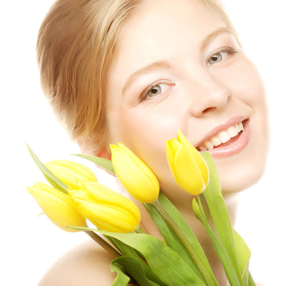 Young smiling woman with yellow tulips - 写真・画像