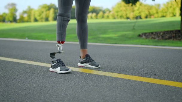 道路に義足の女性が立っている。公園で走る準備をしている足 - 写真・画像