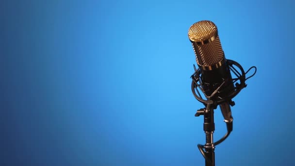 Asztali mikrofon kábellel az alján, hogy kanyarokban és világítás változások, a gradiens kék háttér. - Felvétel, videó