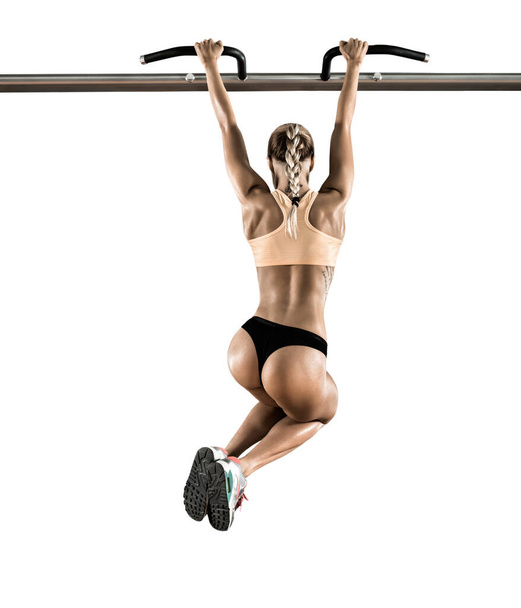 young fitness woman chin-up on horizontal bar on white background, isolated - Fotoğraf, Görsel
