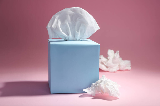 Box of paper tissues and used crumpled napkins on pink background - Fotoğraf, Görsel