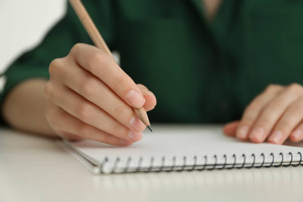 Mulher desenho com lápis no bloco de notas na mesa branca, close-up - Foto, Imagem