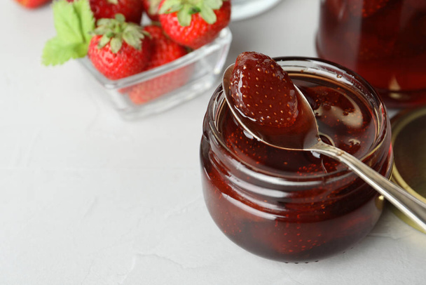 Delicious pickled strawberry jam and fresh berries on light table. Space for text - Zdjęcie, obraz