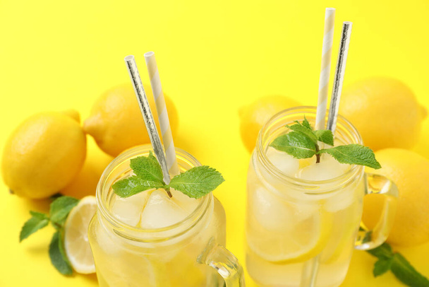 Natural freshly made lemonade with mint on yellow background, closeup. Summer refreshing drink - Fotografie, Obrázek