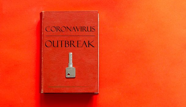 κόκκινο βιβλίο με κείμενο Coronavirus Outbreak και ένα κλειδί σε κόκκινο φόντο - Φωτογραφία, εικόνα