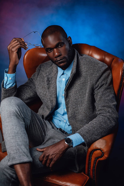 A serious african man looking and sitting on expensive seat - Photo, Image