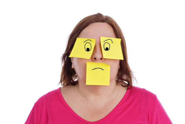 femme en surpoids ayant des notes collantes collées sur ses yeux et sa bouche faisant une expression comique avec des dessins sur fond blanc isolé - Photo, image
