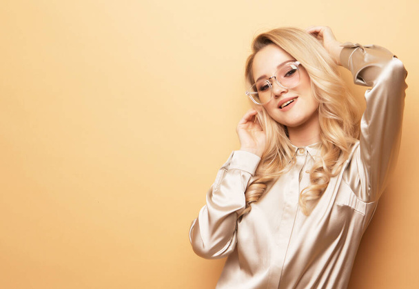 Young blond woman in blouse and pants, wearing sunglasses . - Foto, Imagen