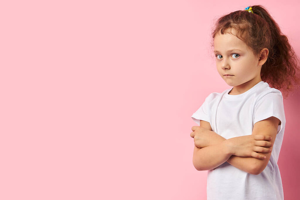 Πορτρέτο του φοβισμένου μικρού κοριτσιού απομονωμένο σε ροζ φόντο - Φωτογραφία, εικόνα