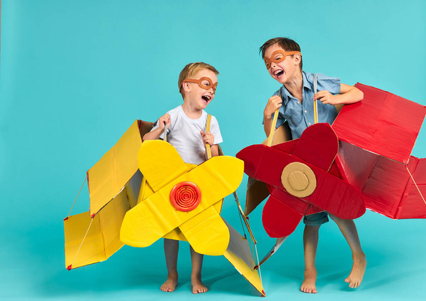 Positive kids wearing airplane boxes - Fotó, kép