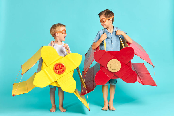 Little children in toy airplane against blue background - Фото, зображення