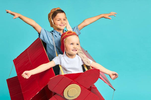 Excited little boys flying on red toy airplane - Photo, Image