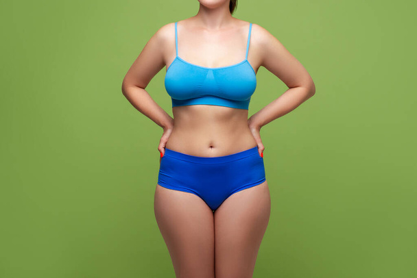 Beauty woman in blue underwear with big natural breasts on green background, body care concept - Fotografie, Obrázek
