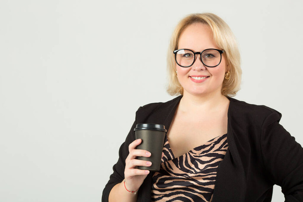 mooie jonge vrouw op witte achtergrond in bril met een kopje koffie - Foto, afbeelding