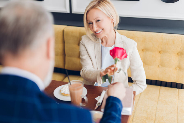 man gives a rose to a blond beautiful smiling woman, happiness concept - Fotografie, Obrázek