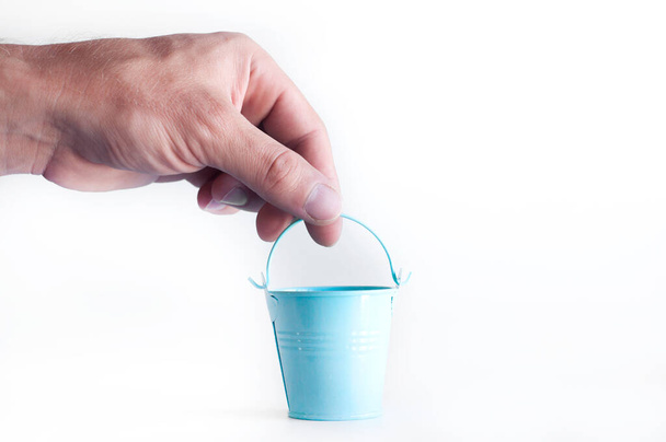 Miniature bucket in hand. On a white background - Photo, Image