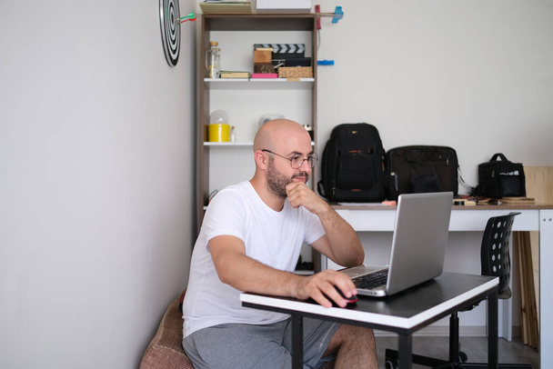 Adolescente trabalhando em um computador, recebendo educação à distância em casa. - Foto, Imagem