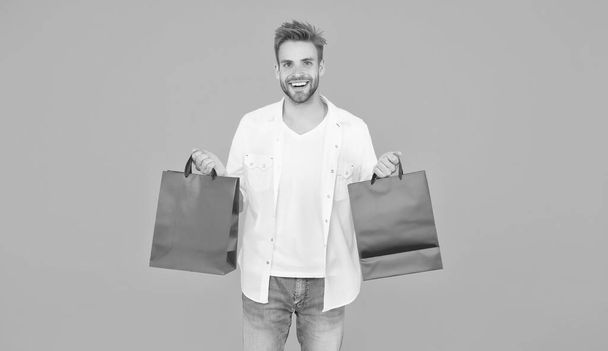 guy happy about his purchase. successful shopping online. male shopper hold packages. shopping bag with goods. How to save money while sale. cyber monday concept. goods for men - Valokuva, kuva