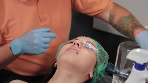 Un truccatore permanente si fa tatuare sulle palpebre superiori di una donna. - Filmati, video