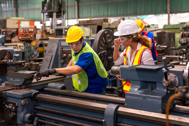 Technici en ingenieurs werken aan industriële machines in de fabriek. - Foto, afbeelding